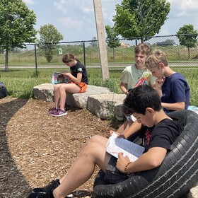 des élèves lisent à l'extérieur